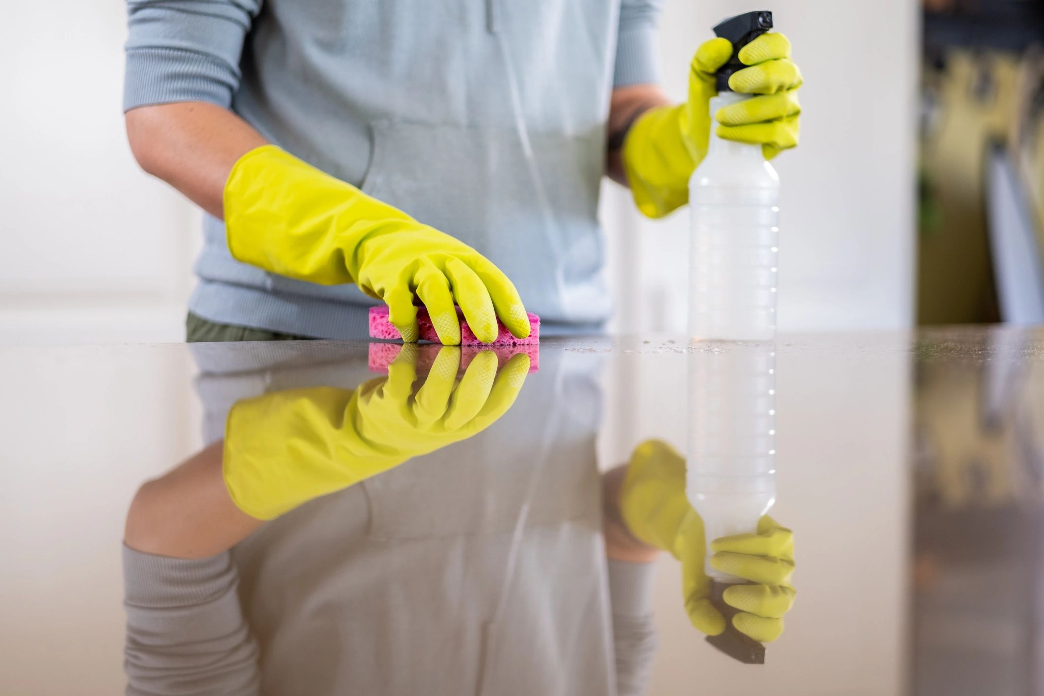 Professional cleaner sanitizing a kitchen counter